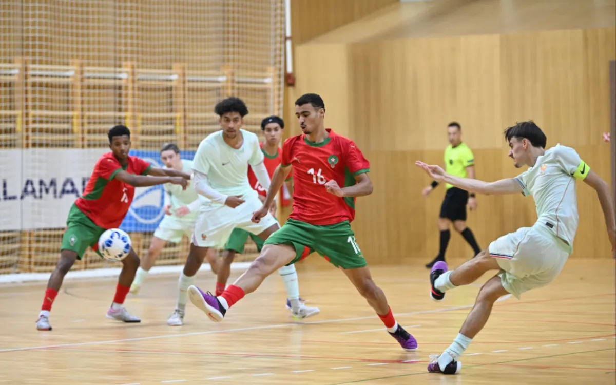 Joueurs marocains en rouge et vert face à des joueurs français en blanc sur un terrain de futsal