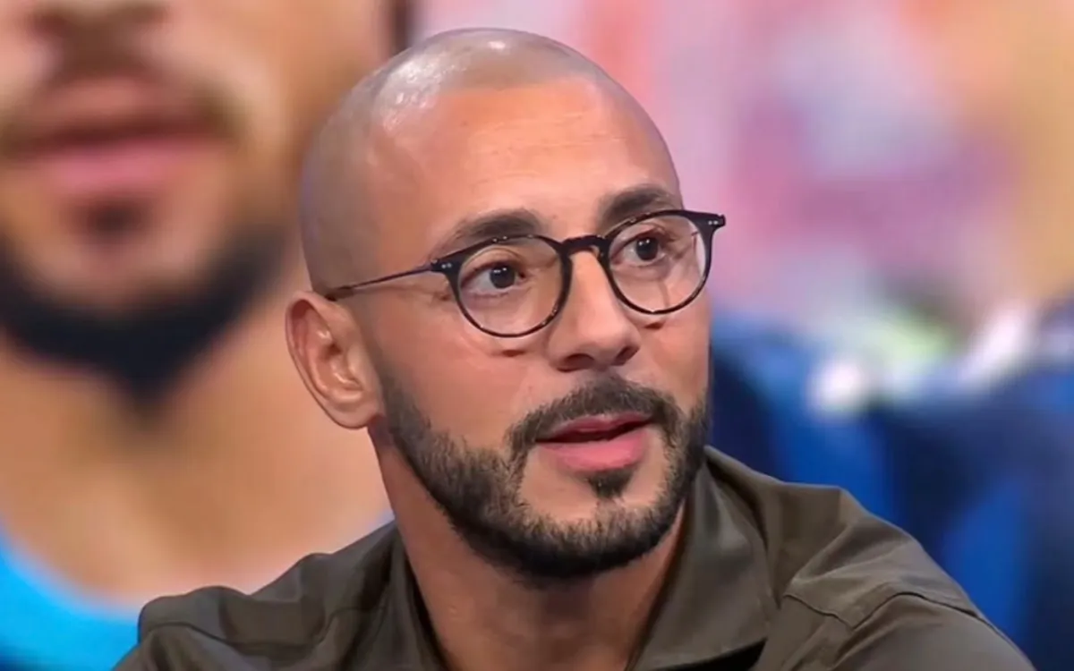 Portrait de Nordin Amrabat portant des lunettes lors d’un entretien télévisé